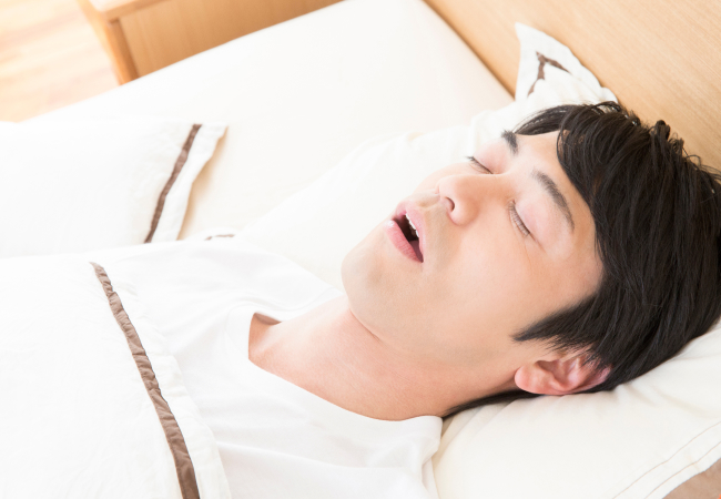 口を開けて眠る中年男性