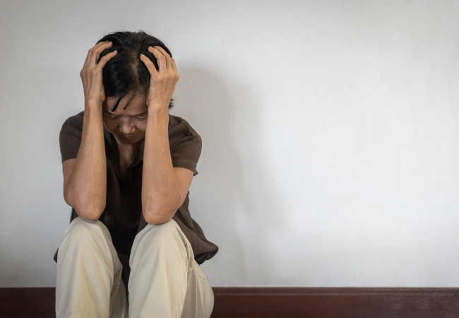 頭を抱えて座り込む女性